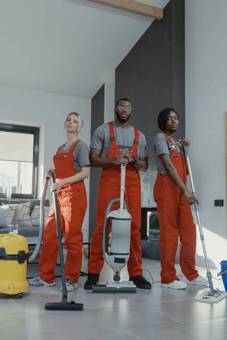 Cleaning professionals | Newcastle Carpet Cleaning Three cleaning professionals in uniform standing with vacuum equipment, Newcastle Carpet Cleaning