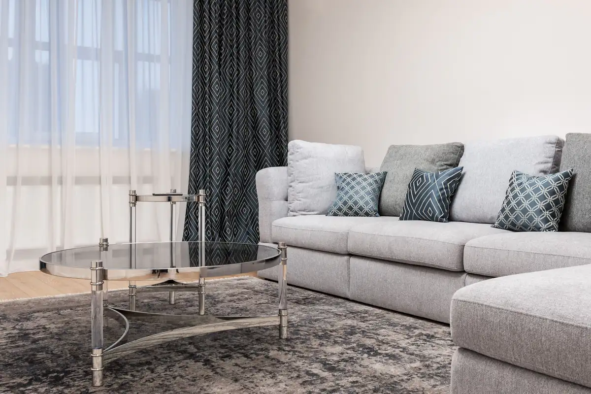 Bright modern living room with a clean grey carpet and a light sofa, carpet cleaning in Newcastle