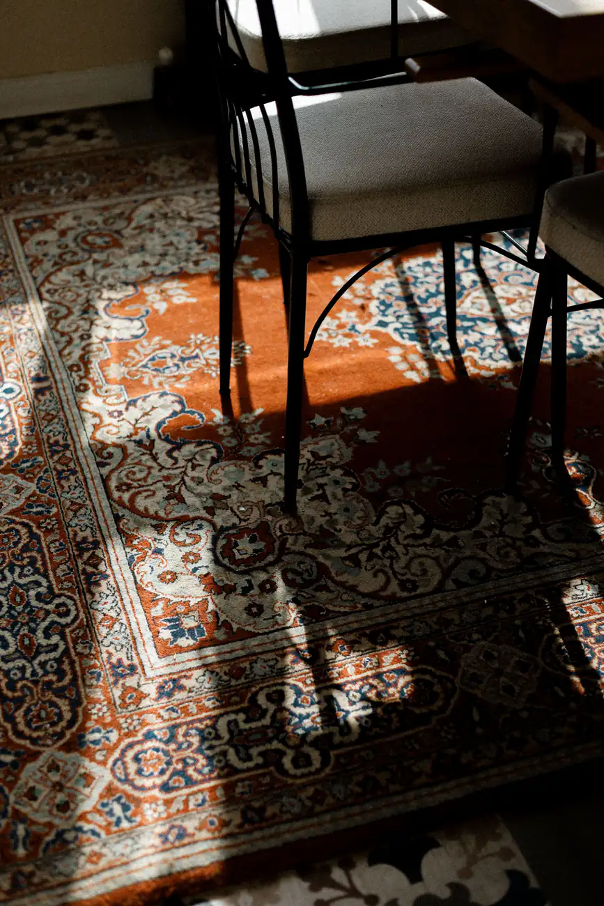 Ornate traditional rug in a sunlit room with chairs, carpet cleaning in Whitley Bay